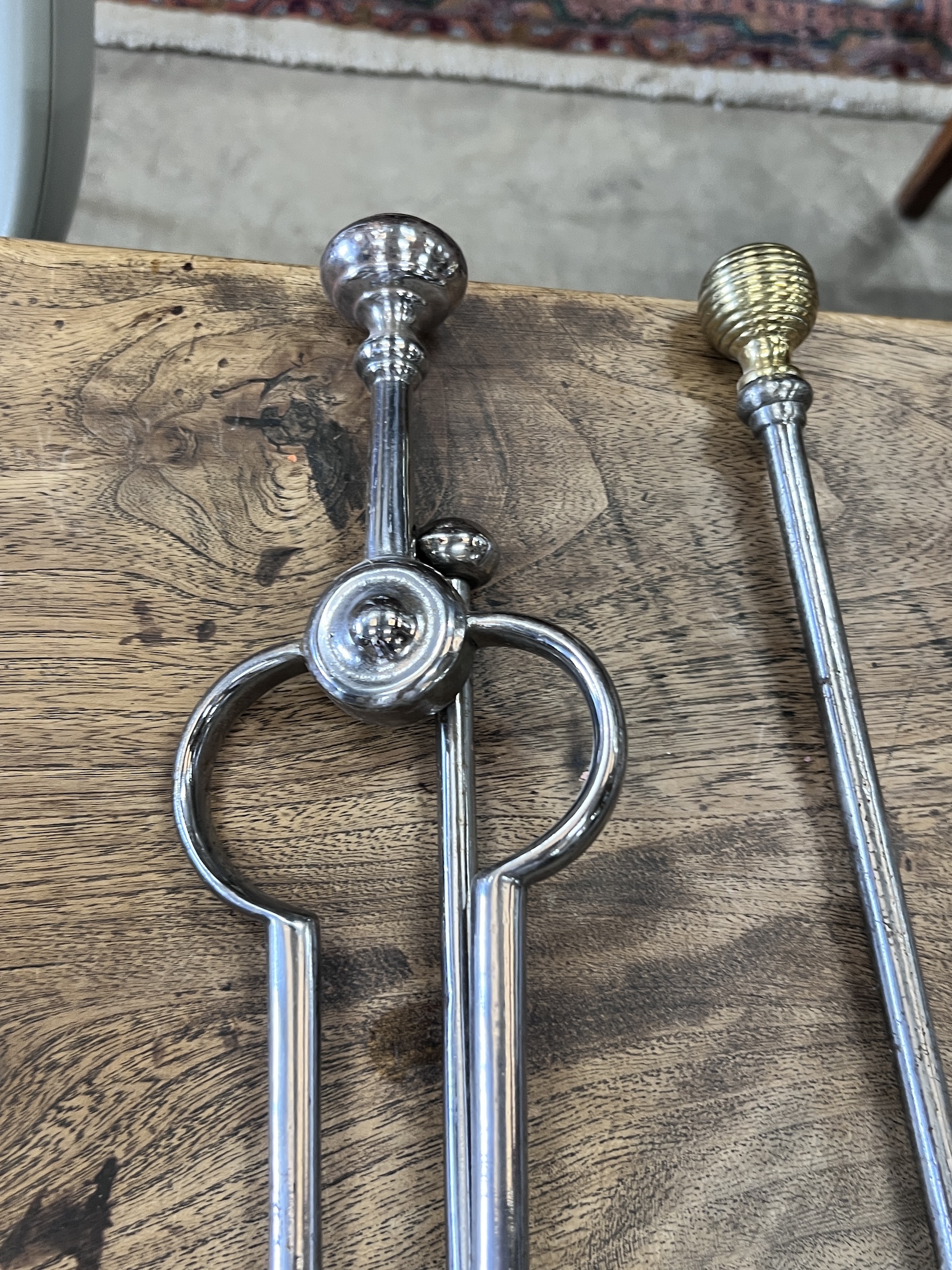 A set of three brass mounted steel fire implements together with a pair of tongs and a poker